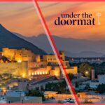 Sunset view of historic fort in Oman with UnderTheDoormat and OMRAN logos, highlighting investment in Oman short-term rentals market