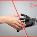 Human hand shaking a robotic hand symbolizing Airbnb’s AI strategy and the integration of artificial intelligence in travel personalization.