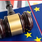 A wooden judge's gavel resting on the European Union flag with a red diagonal strike-through, symbolizing legal enforcement and penalties for short-term rentals under EU Regulation 2024/1028.