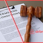 A conceptual photo illustrating the April 2026 Airbnb terms of service update for property managers, featuring a legal gavel, a document titled 'TERMS AND CONDITIONS', and the Airbnb logo.
