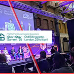 Tarification pour les courts séjours : Comment les gestionnaires de biens immobiliers britanniques PEUVENT gérer des réservations plus courtes et la hausse des coûts 4 A photo from the audience of a panel discussion at the STAA Short Stay Summit '26. The stage backdrop features logos for Short Term Accommodation Association and Vrbo, and experts are seated discussing insights related to short term rental pricing strategy and guest behavior.