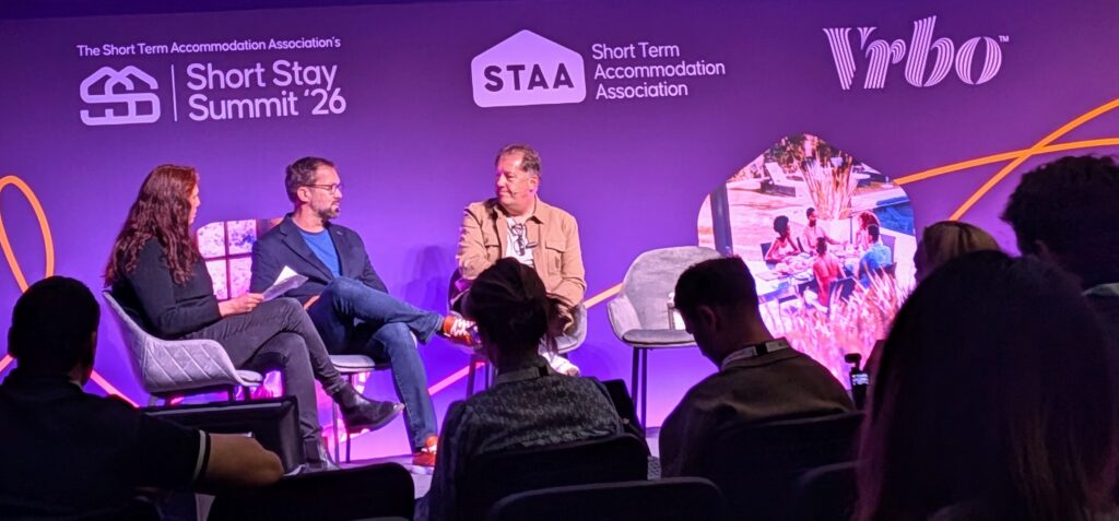 A panel discussion at Short Stay Summit '26 on AI for vacation rentals 2026, featuring Graham Donoghue and Steve Schwab.