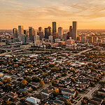 Aerial view of Houston and Washington DC residential neighbourhoods and skylines at golden hour — short-term rental regulations 2026